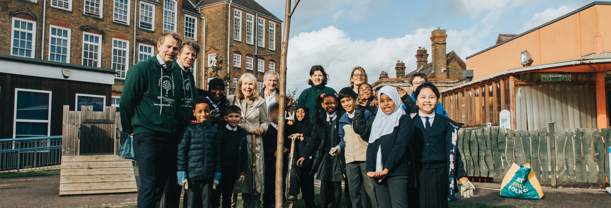 Teachers & students standing around a tree