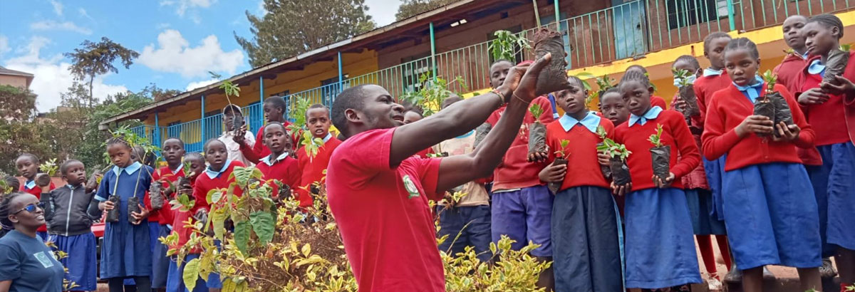 Teachers & students holding saplings ready for planting